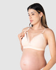 Close-up of Kami, pregnant mother of two, demonstrating the functionality of the HOTMILK US nursing and maternity bra named AMBITION T-SHIRT WIREFREE in shell pink, featuring the convenient magnetic nursing clip