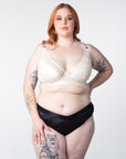 Ali, stunningly shows off the Warrior Plunge Ivory nursing and breastfeeding bra by Hotmilk Lingerie. Featuring an edgy design, graphic lace, and magnetic clips for added flair, this ensemble is elevated by the supportive features of contour cups and flexi underwire, providing both comfort and lift