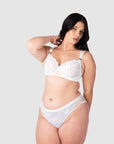 Elevate your style as a bride or wedding guest with Hotmilk Lingerie's True Luxe maternity and nursing bra in crisp white. The soft twin lace strap details and semi-sheer floral lace add a touch of elegance to breastfeeding. This set allows you to embrace your individual style while receiving expert support and lift for larger bust sizes up to J cup. It's the perfect choice for capturing the radiant beauty of maternity photo shoots