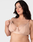 Model demonstrating one-handed nursing clip release on the Hotmilk Flawless Plunge Wirefree Nursing Bra in Cashmere – showing easy breastfeeding access via side-sling design