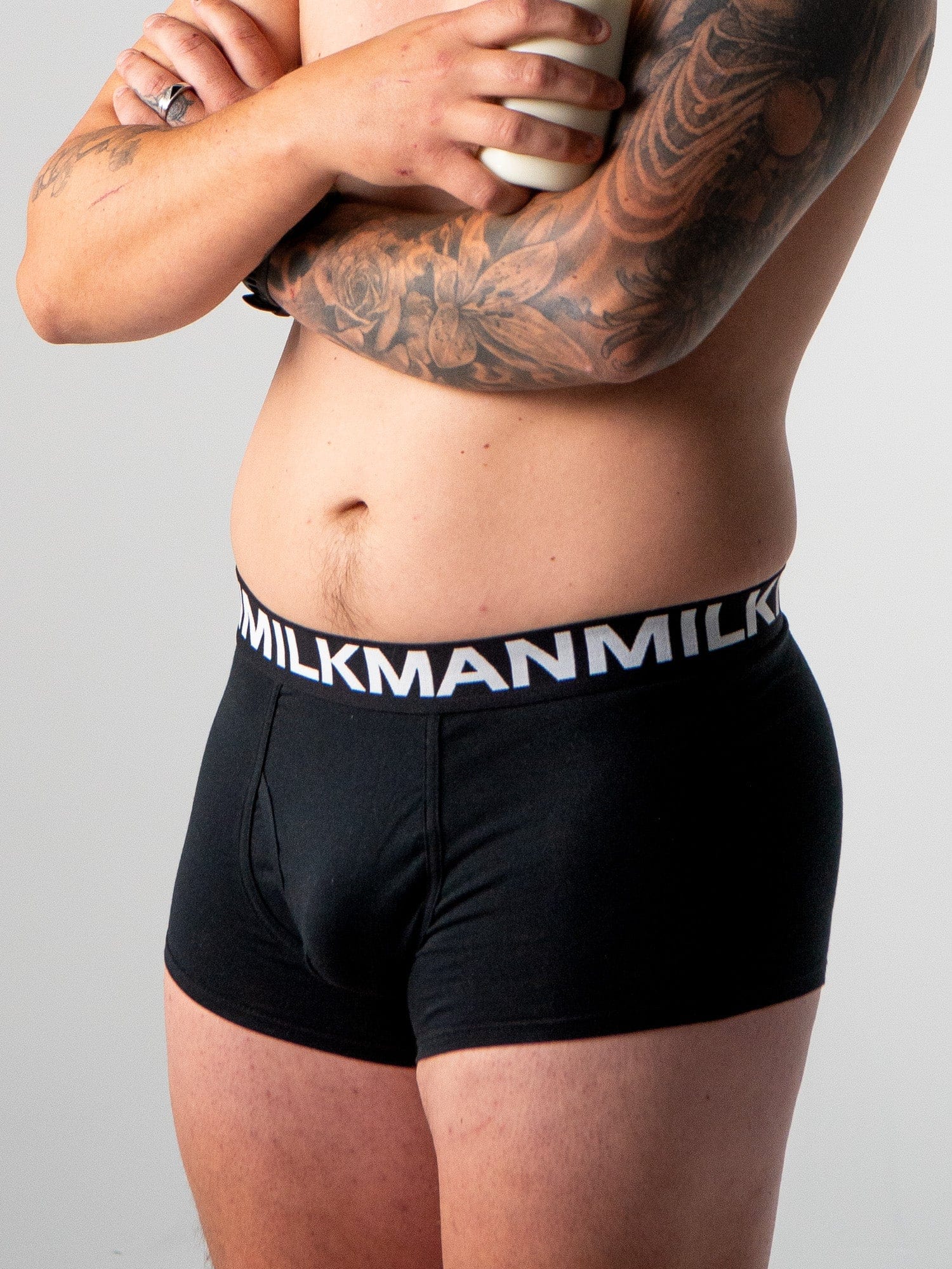 Man wearing black underwear with 'Milkman' waistband on a gray background