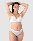 Taitiana, a mother of 2, confidently showcases the best-selling nursing lingerie set from Hotmilk Lingerie. She pairs the True Luxe nursing bra in white with the matching semi-sheer floral lace bikini. This set allows you to embrace your individual style while receiving expert support and lift for larger bust sizes up to M cup. It's the perfect choice for capturing the radiant beauty of maternity photo shoots